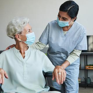 A health-care worker helps a patient