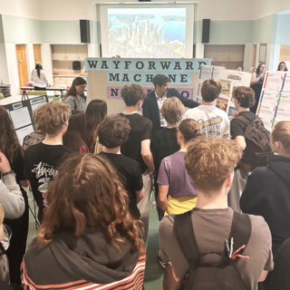 Michael MacKenzie showing a group of students some of the work done for the Futures Fair.