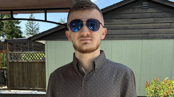 Zackary Sutton outside wearng sunglasses and looking at the camera