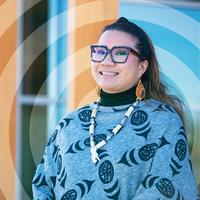 Smiling young woman wearing modern Indigenous clothing.