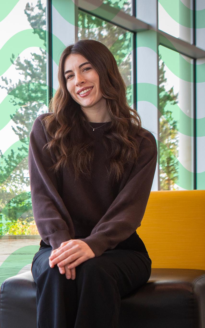 A smiling young woman sitting in front of a window